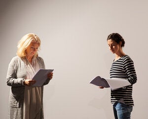 two women reading scripts