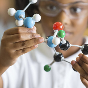 young child studying three-dimensional molecule