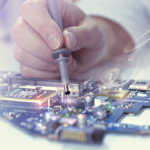 close-up of masculine hand soldering a circuit board
