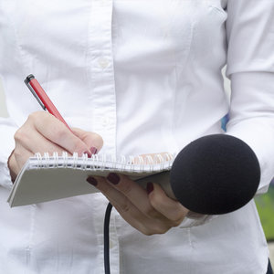 journalist with notebook and microphone