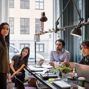 Creative businesswoman giving presentation to colleagues in modern office