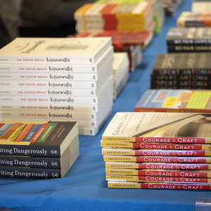 Stack of books published by Writers Program instructors