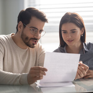 two people looking over a paper contract