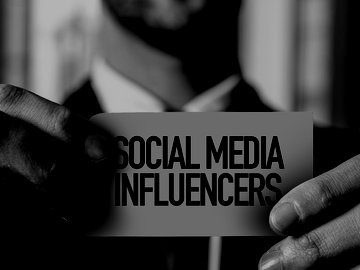 man holding card with text that reads "social media influencers"