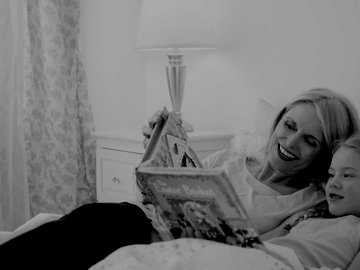 Senior woman and granddaughter reading in bed