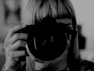 Woman with DSLR camera pointed forward