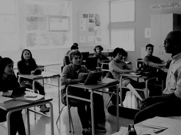 High school students listening to teacher in classroom