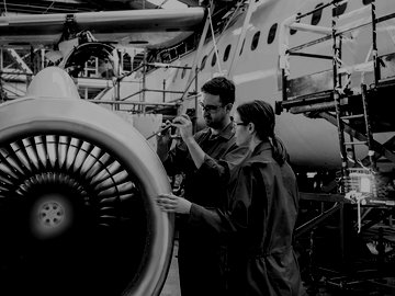 Workers using traditional tools manufacturing aircraft
