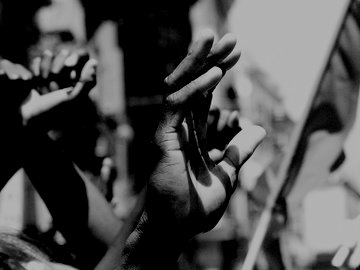 black and white image of hands raised in protest
