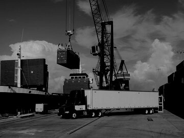 tractor trailer sits in the foreground at a commercial dock
