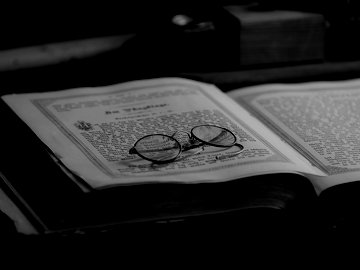 Reading glasses resting on a rare book