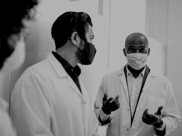 Medical professionals in masks having a discussion