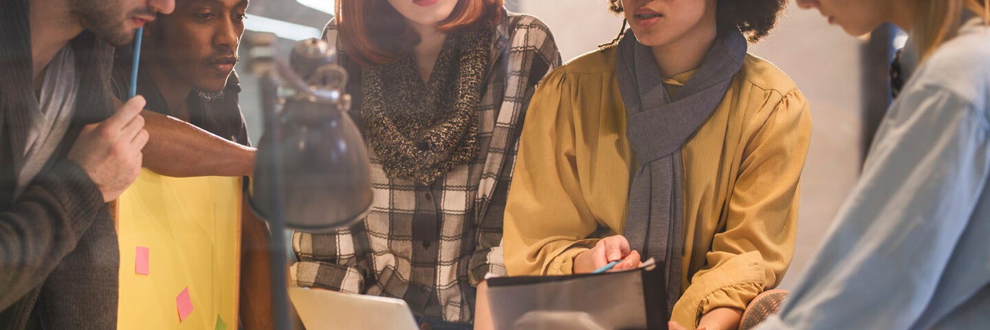 Students collaborating around a desk on a project