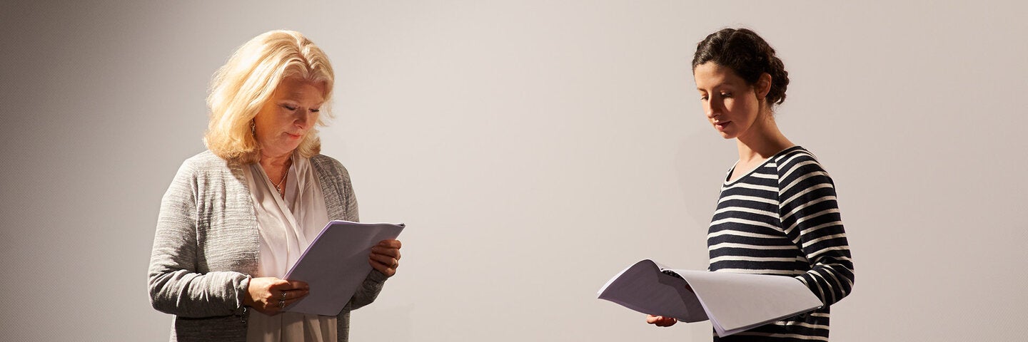 two women reading scripts