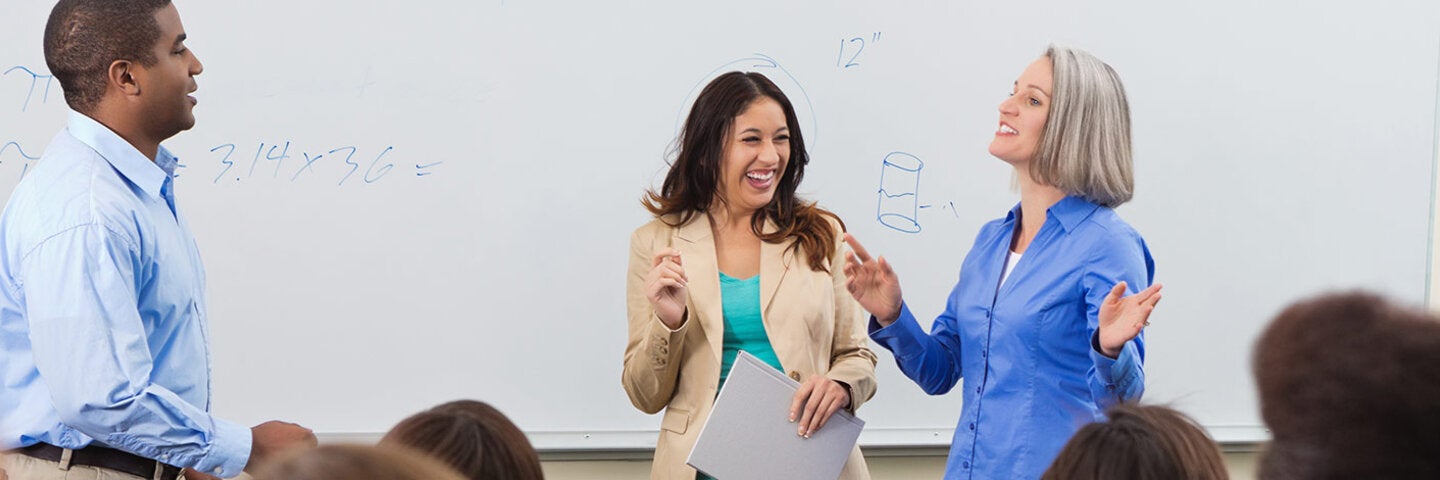 Instructor and students going over math on a whiteboard