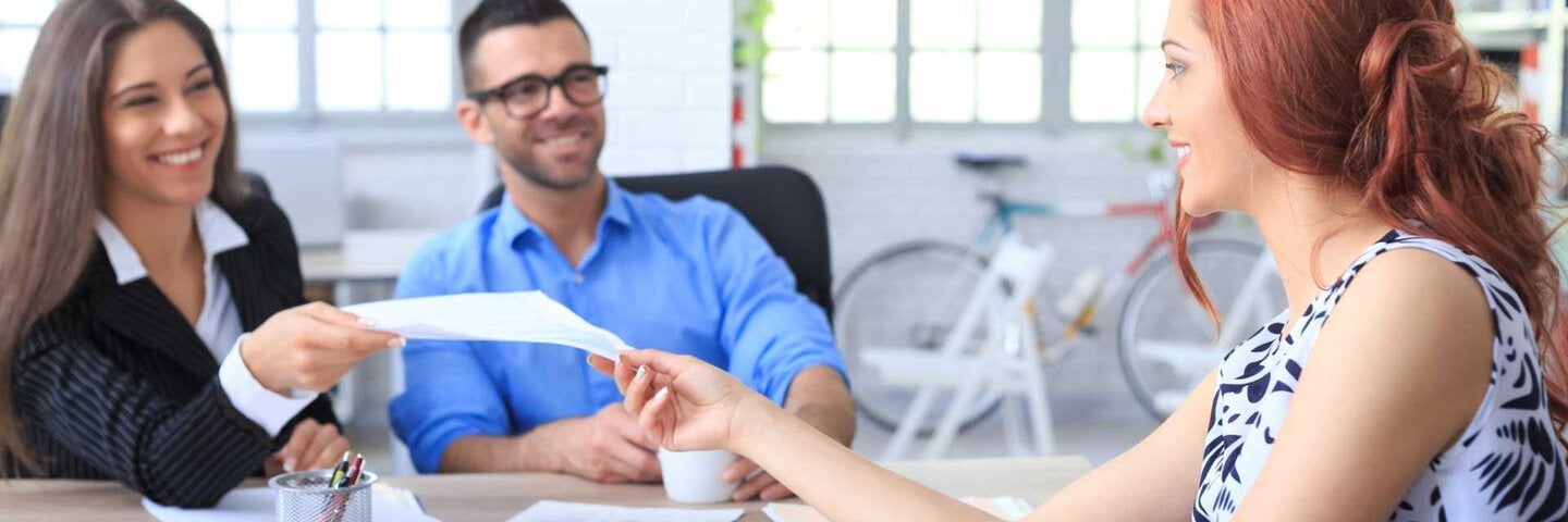 Female accounting passing out financial documents in a meeting.