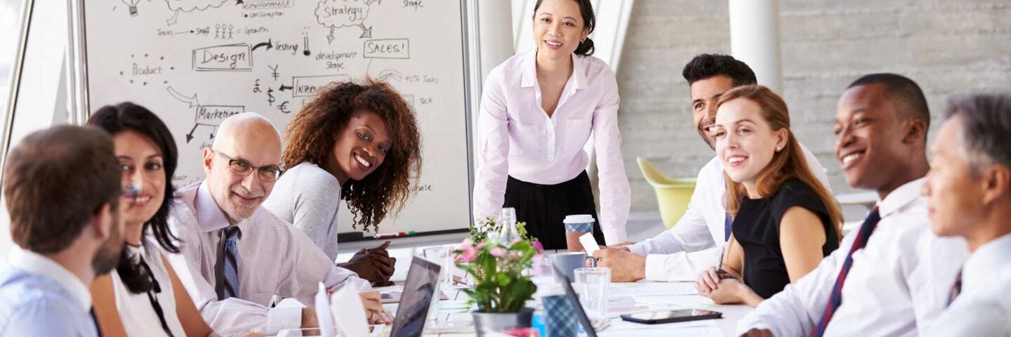 Asian Businesswoman Leading Meeting At Boardroom Table