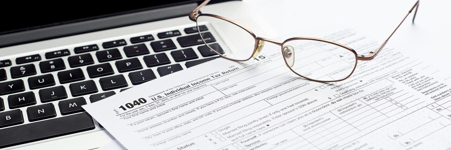 U.S. 1040 income tax return form with laptop and glasses