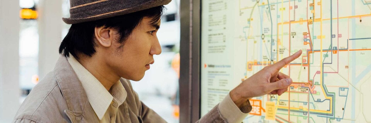 An international student checking the bus and subway map.