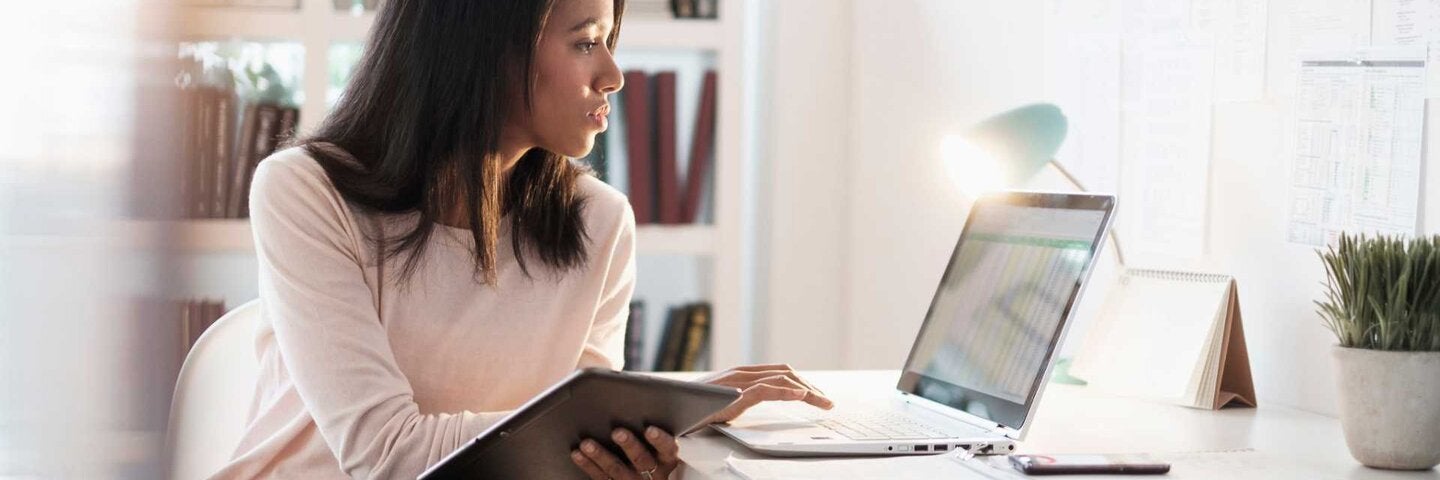 Woman looking up information on laptop at home.