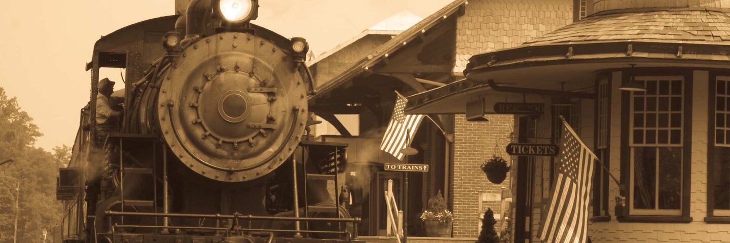 Vintage Antique Steam Locomotive At Railroad Station