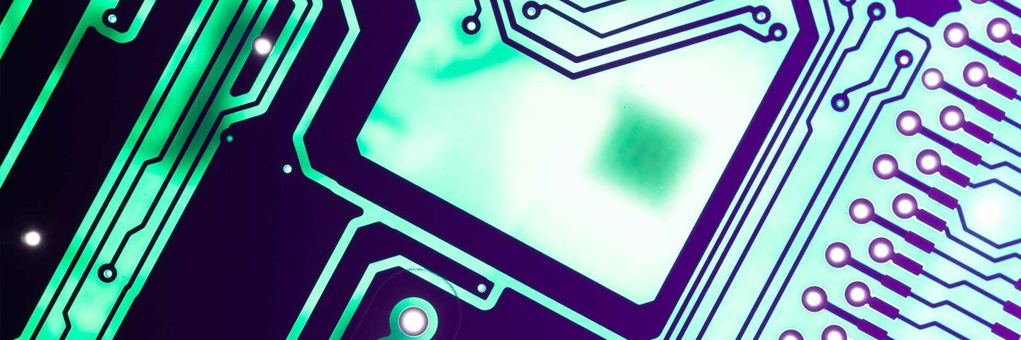 Green Colored Printed Circuit Board with Ultraviolet Light Glow Macro View.