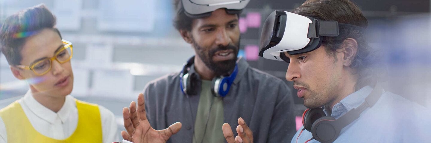 Computer programmers with digital tablet programming virtual reality simulators