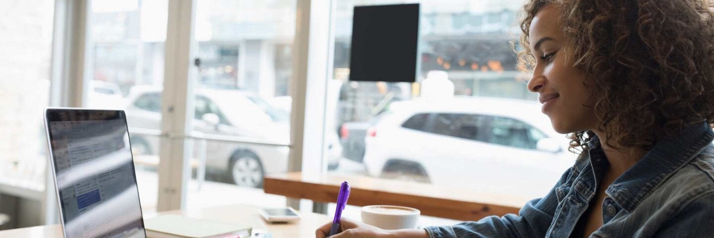 female writer with laptop and notebook
