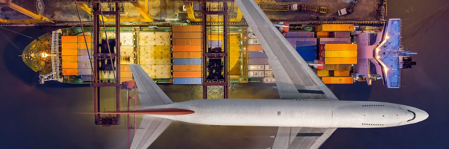 airplane flying over a stocked tanker ship