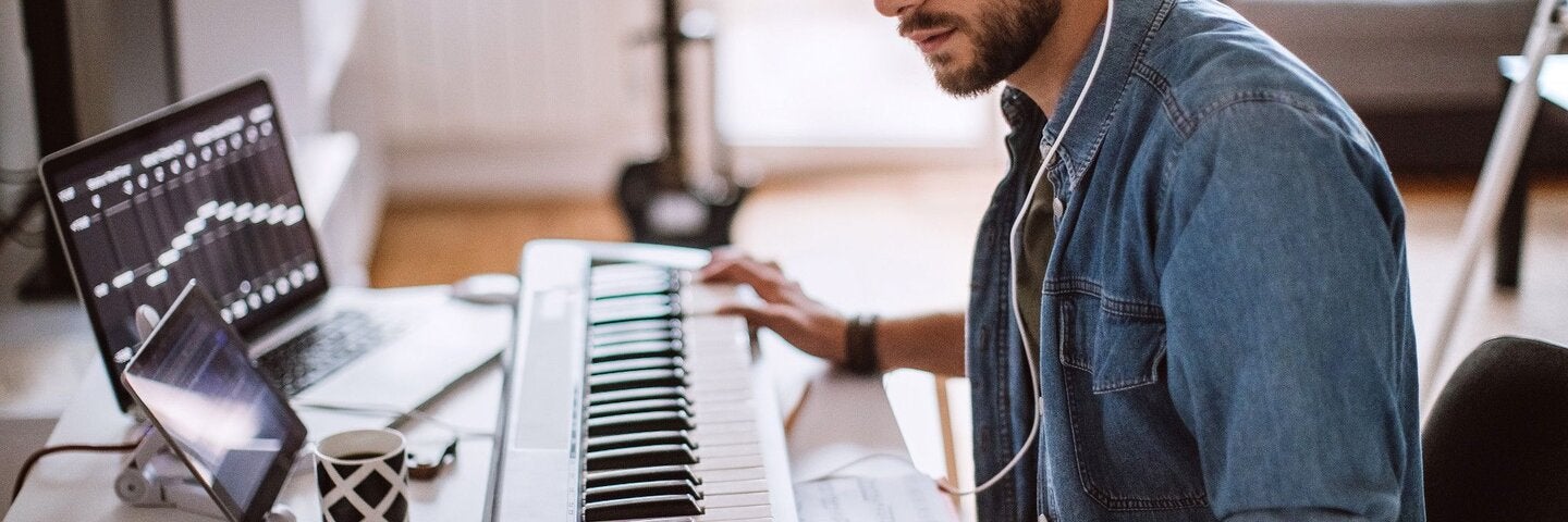 man wearing headphones using a keyboard