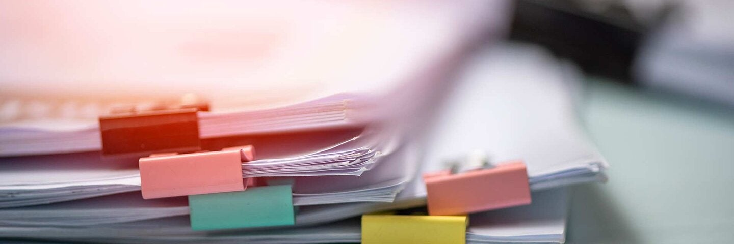 Stack Of Paper With Binder Clips On Table