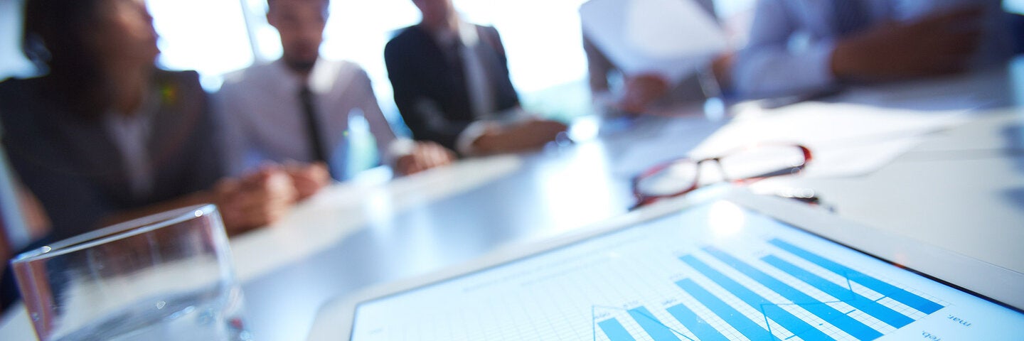 Business meeting with data on tablet