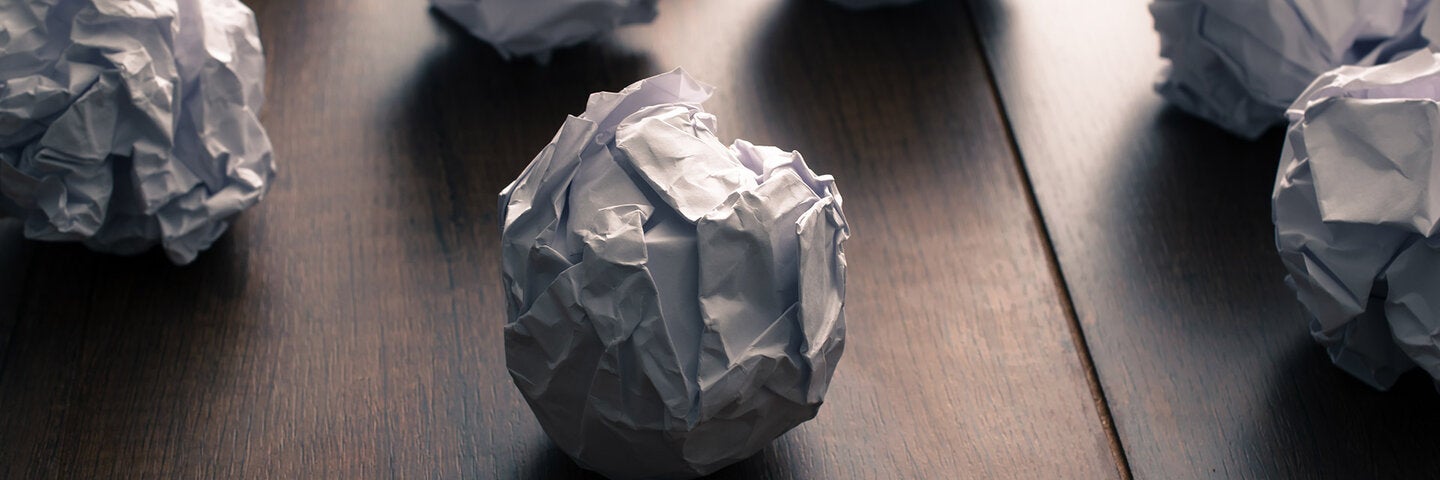 wadded up paper balls on a desk