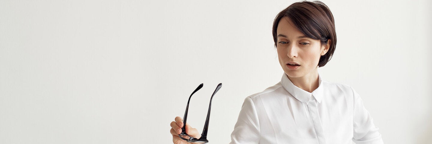 Stylish woman taking off her glasses