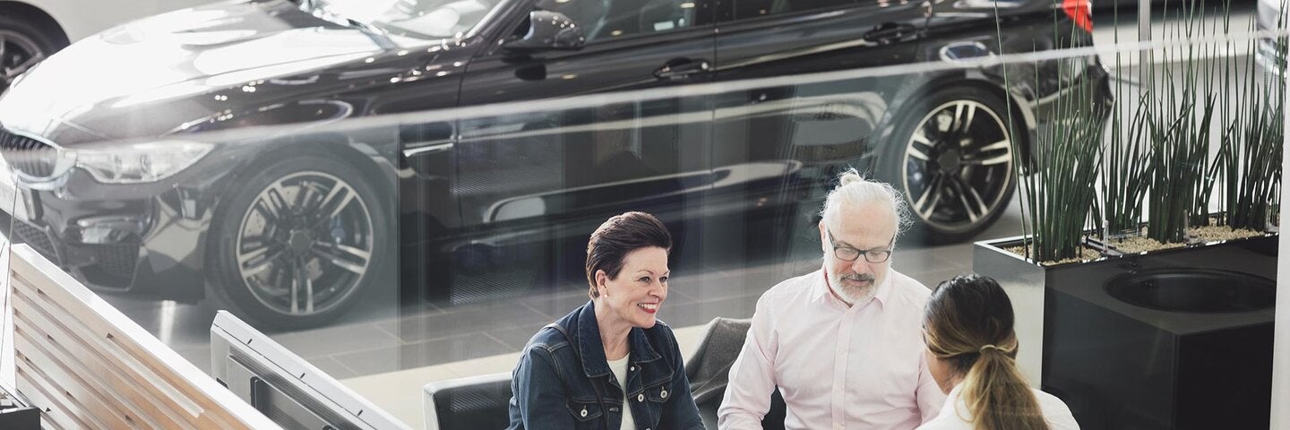 three individuals seated adjacent to a parking lot