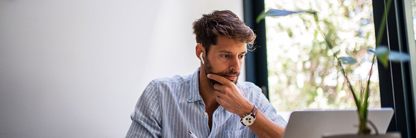 Young man analyzing text on his laptop