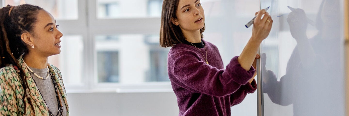 woman demonstrating a concept on the white board