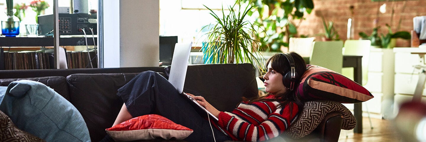 woman writing and relaxing on her sofa