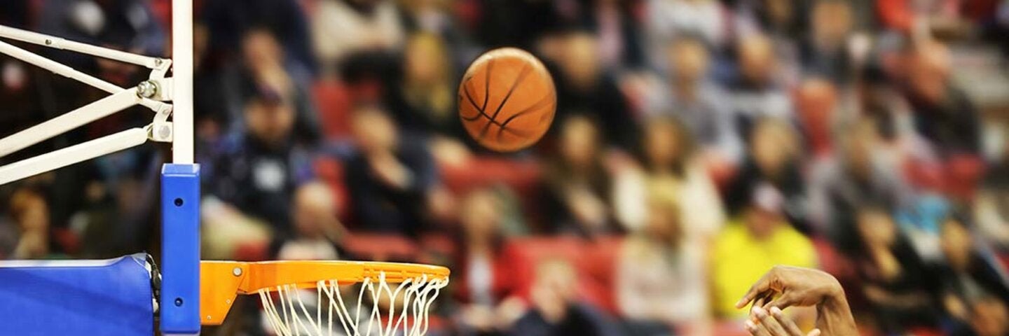 Action shot of a basketball game representing sports management and industry education programs.