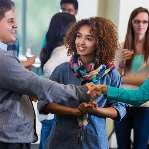 people shaking hands at networking event