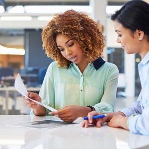 two professional woman collaborting on work items